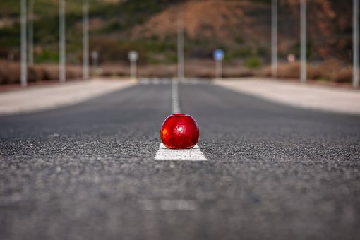 Perfect road with a red apple placed on the white line laid by road construction companies