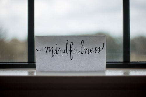 Piece of paper that reads "mindfulness" on a window sill to remind us to let things go